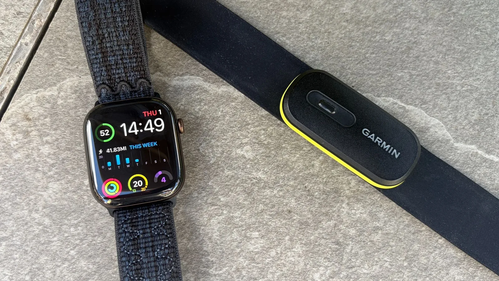 An Apple Watch Series 12 lying beside a Garmin HRM 600 chest strap