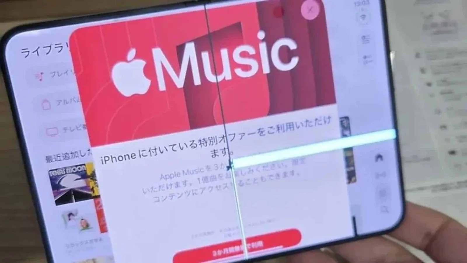 An iPhone Duo's inner screen with a crack running down the fold and a bright line of dead pixels across it