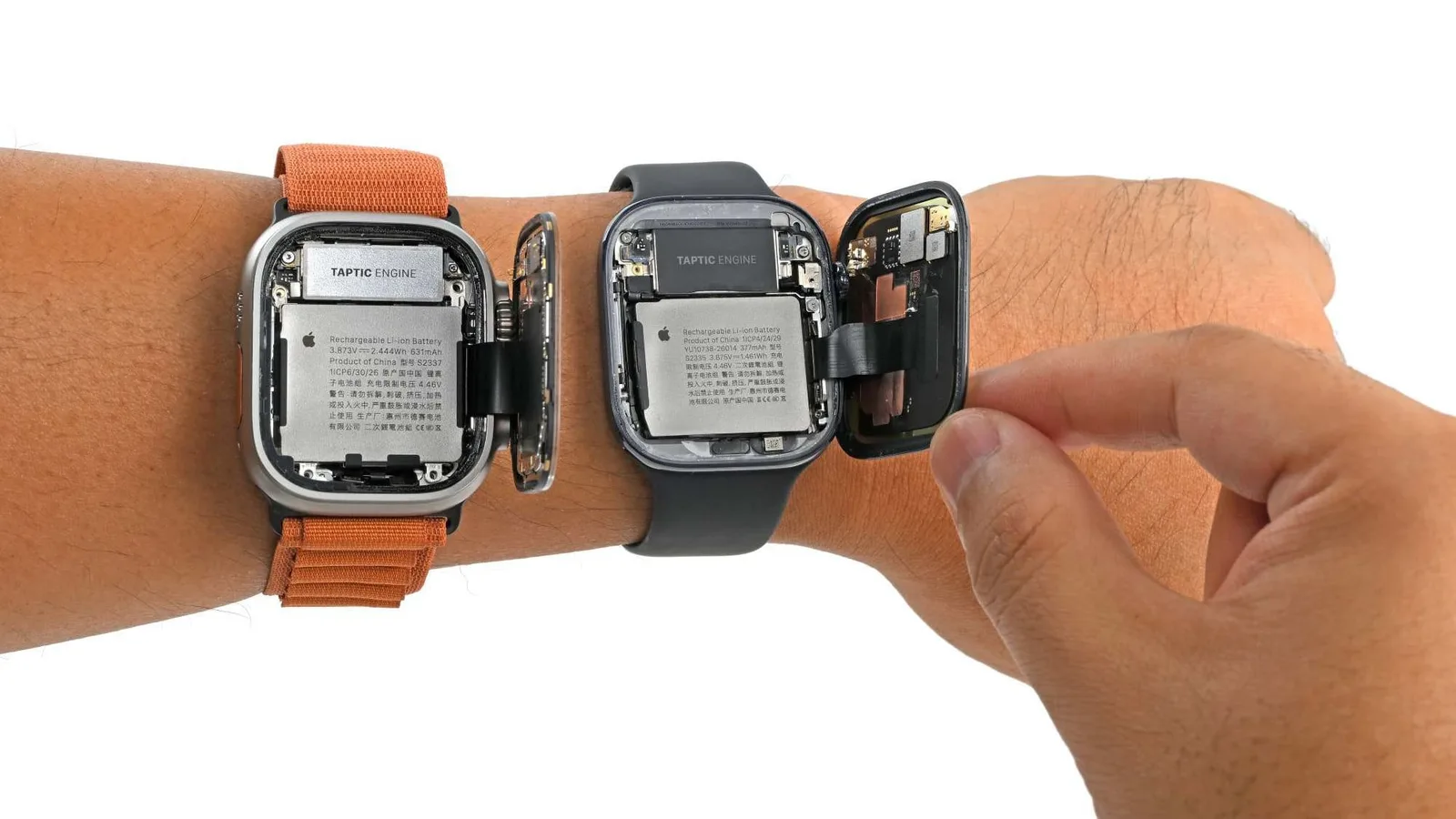 iFixit's teardown of two Apple Watch models with their backs opened to show the batteries