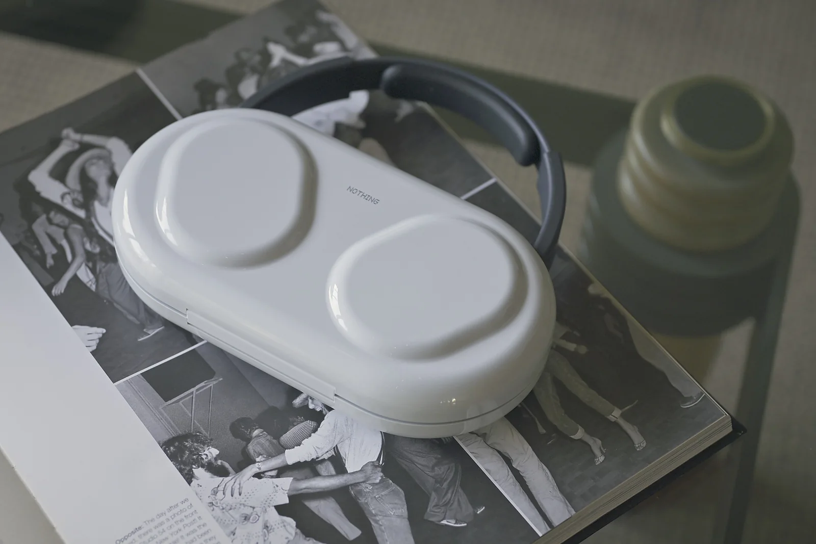 The white Nothing Headphone (1) Pro hardshell case on an open book